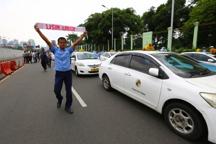 Conventional taxi drivers stage a rally against the ride-hailing services in front of the Merdeka Palace in Jakarta on March 14, 2016.  
