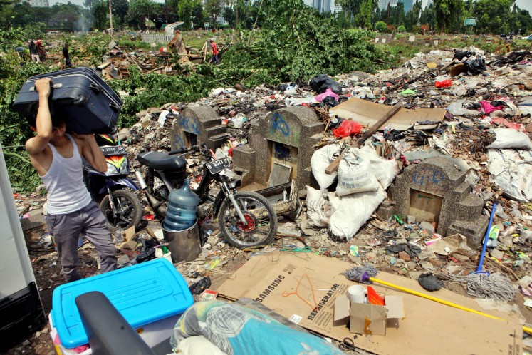 A resident of Menteng Pulo Cemetery collects his belonging after he was evicted in April 2016. Over 250 illegal buildings, which were built on graves, were demolished. 