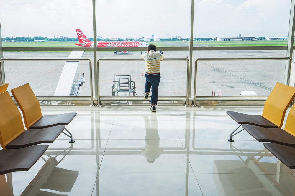 A boy looks at an AirAsia plane that is preparing for take-off at an airport terminal in Surabaya, East Java, on June 22, 2016. Image: Shutterstock.com/dreamstory