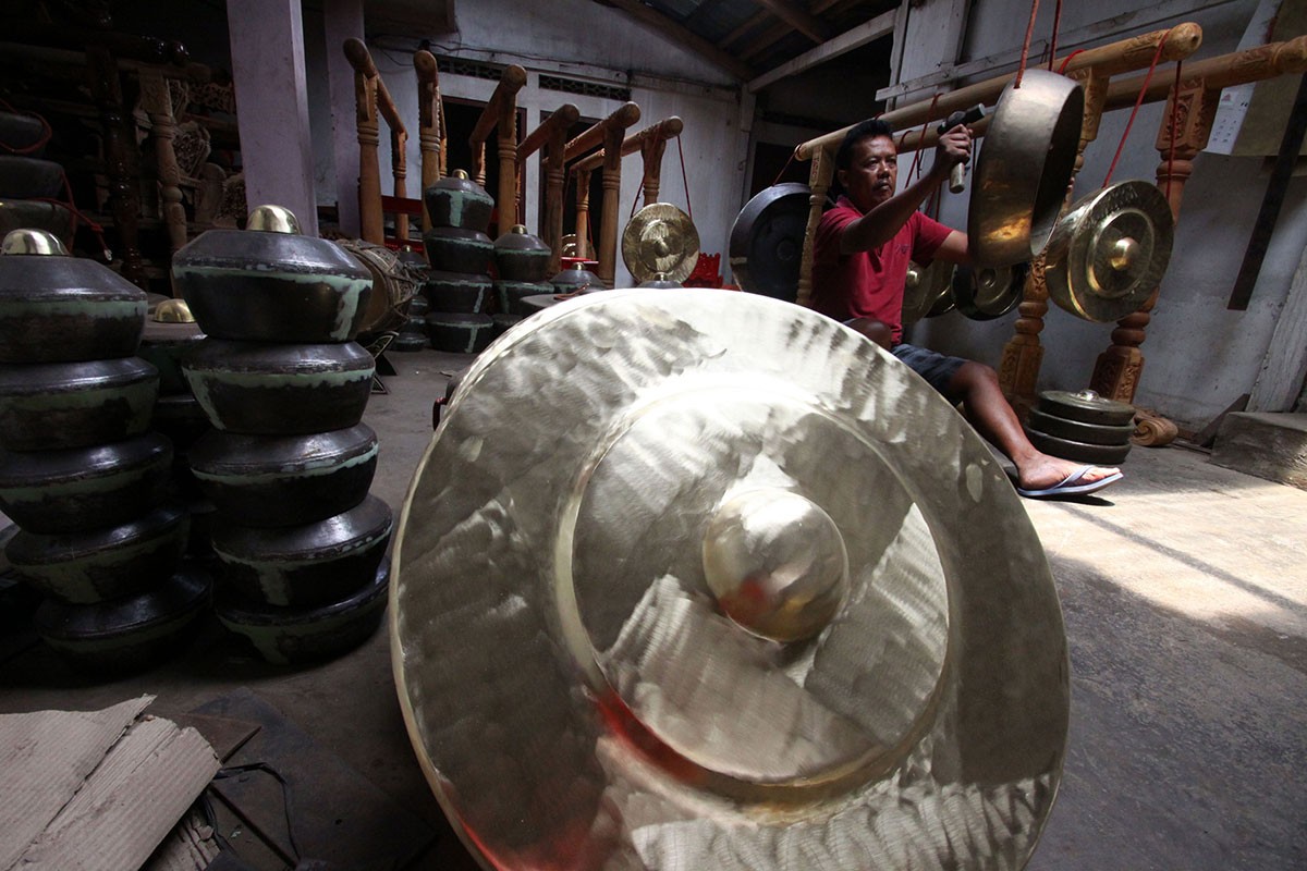 Legiono checks the tune of a gong using a master gong, called the “baboon”, as the benchmark. Image: JP/Aditya Sagita