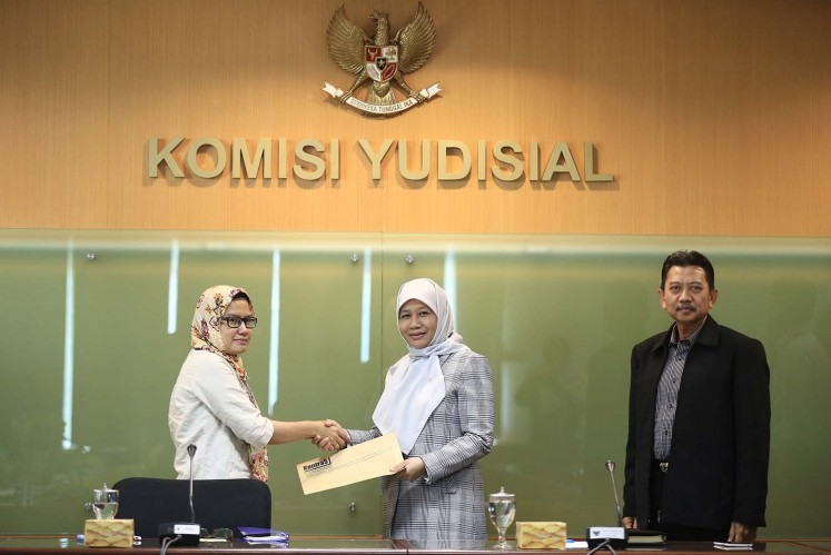 The Commission for Missing Persons and Victims of Violence (KontraS) Yati Andriyani (left) hands over a report on trial proceedings related to the death of human rights defender Munir Said Thalib to Judicial Commission deputy chairman Sukma Violetta (center) in Jakarta, on Feb. 21.