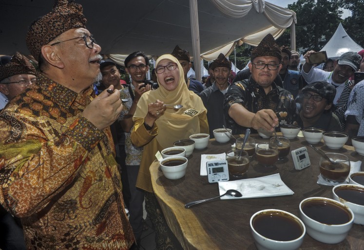 West Java Deputy Governor Deddy Mizwar (left) accompanies Governor Ahmad Heryawan (right) and his wife Netty Heryawan at a coffee event, 