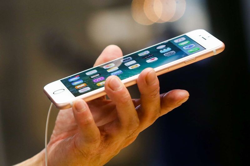 A man holds an iPhone 7 Plus. Image: Bloomberg/Chris Ratcliffe