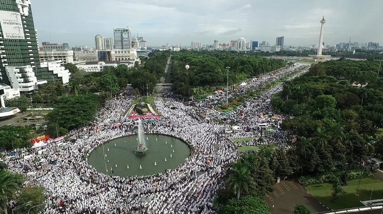 This aerial view shows Indonesian Muslims gathering at Jakarta's National Monument Park as part of a rally against Jakarta's Christian Governor Basuki Tjahaja Purnama, better known by his nickname Ahok, on December 2, 2016. More than 100,000 Indonesian Muslims protested on December 2 against Jakarta's Christian governor, the second major demonstration in a matter of weeks as conservative groups push for his arrest on accusations of insulting Islam.