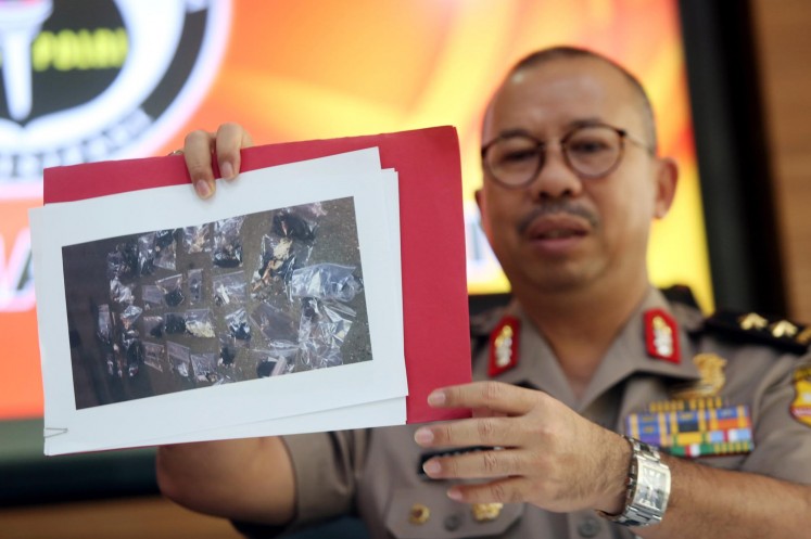 National Police spokesman Insp. Gen. Setyo Wasisto holds up a photograph during a press conference in Jakarta on May 25.