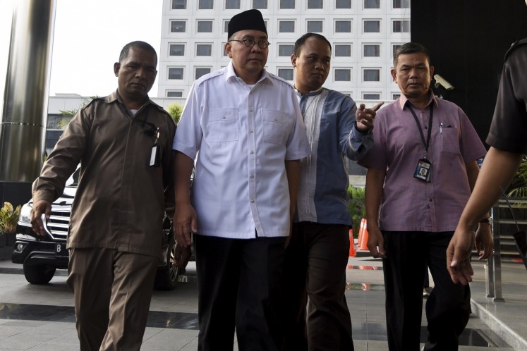 Bengkulu Governor Ridwan Mukti (second left) is escorted by Corruption Eradication Commission (KPK) investigators to undergo a questioning at the anti-graft body headquarters in Jakarta on June 20. 