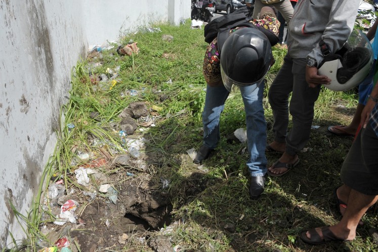Locals examine a hole suspected to be one end of a tunnel four Kerobokan inmates used to escape.  Australian Shaun Edward Davidson, Bulgarian Dimitar Nikolov Iliev, Indian Sayed Mohammed Said and Malaysian Tee Kok King Bin Tee Kim Sai are believed to have escaped from the prison via the tunnel on June 19.