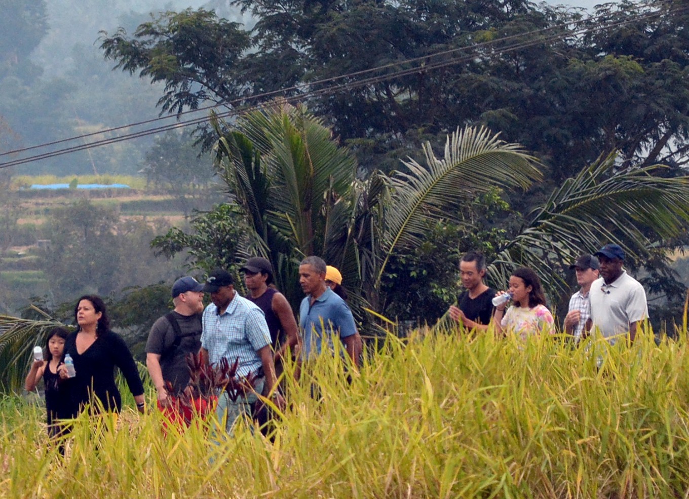 Former US president Barack Obama (center) and his entourage take a break after a walk through the field while visiting the Jatiluwih tourist site in Tabanan on Bali island on June 25. Image: AFP/STR