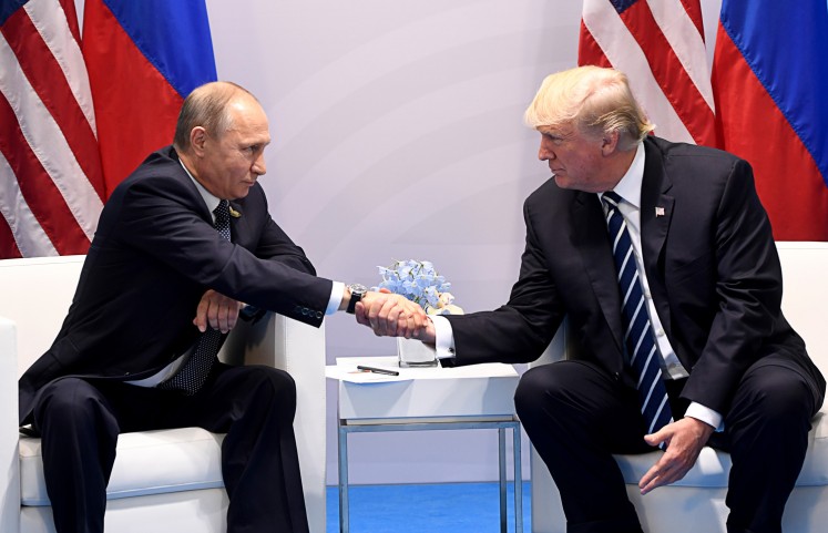 A 'robust' meeting: US President Donald Trump and Russia's President Vladimir Putin shake hands during a meeting on the sidelines of the G20 Summit in Hamburg, Germany, on July 7.
