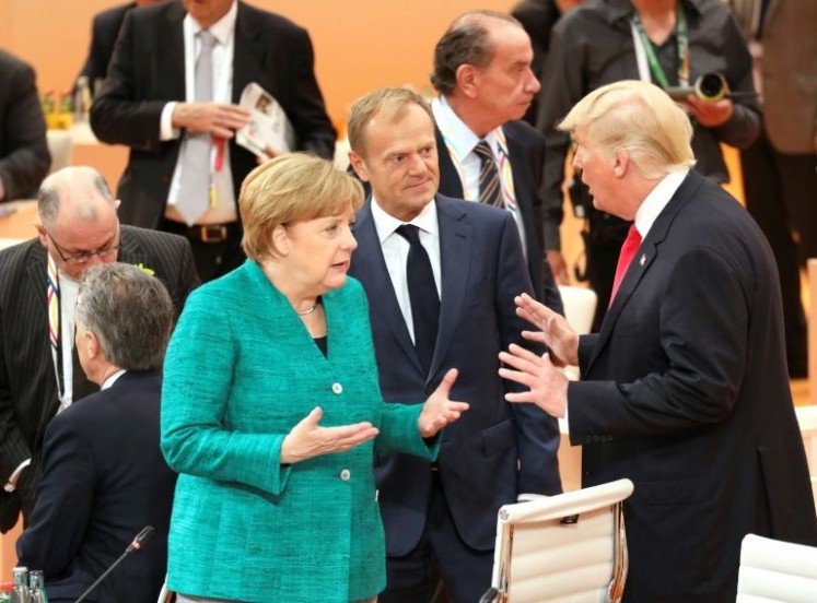 German Chancellor Angela Merkel, the President of the European Council Donald Tusk and US President Donald Trump speak at the beginning of the third working session of the G20 meeting in Hamburg, northern Germany, on July 8, 2017
