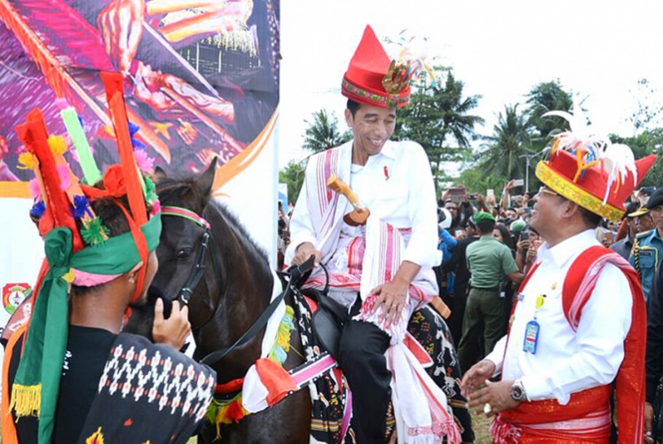 President Joko 'Jokowi' Widodo sits on a sandalwood horse as he talks to Northeast Sumba Regent Markus D. Tallo (right) during the 1001 Sandalwood Parade in Waetabula, Sumba Island, on July 12 2017. 