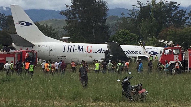 Under investigation: Authorities check the condition of a Tri MG cargo aircraft, which skidded off the runway at Wamena Airport, Papua, on July 18.   