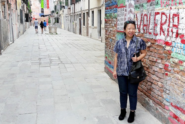 Walk of fame: Artist Tintin Wulia passes an alley in the Arsenale area of Venice, Italy, on her way to the venue of the Art Biennale 2017.