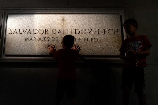 A child touches Salvador Dali's tombstone inside the Teatre-Museu Dali (Theatre-Museum Dali) in Figueras on July 18, 2017 ahead of the exhumation of the artist's remains. The remains of the world-famous surrealist, who is buried in his museum in Figueras, in northeastern Spain, were ordered exhumed after a woman who claims to be his daughter filed a paternity claim.