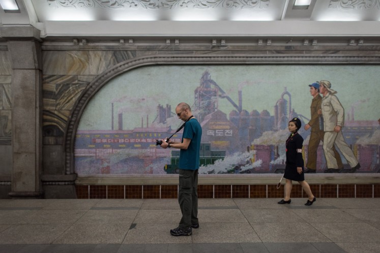 A tourist takes a photo during a visit to a subway station in Pyongyang on July 23, 2017.