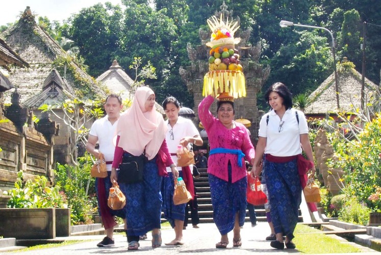 Carefree life: Village residents carry offerings for a traditional ritual to be held at the local village hall.