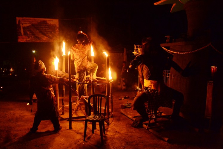 Preparing the torches and 'ogoh-ogoh' for the Buta Yadnya ritual.