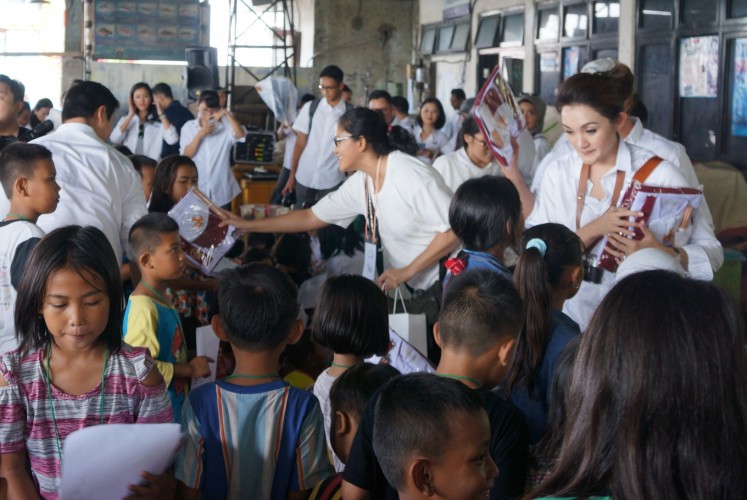 Participants from One Fine Sky distribute sets of uniforms to children on Saturday.