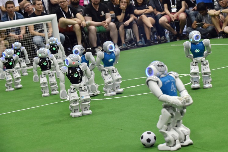 Robots fight for the ball during their football match in the standard platform league tournament at the RoboCup 2017 in Nagoya, Aichi prefecture on July 30, 2017.