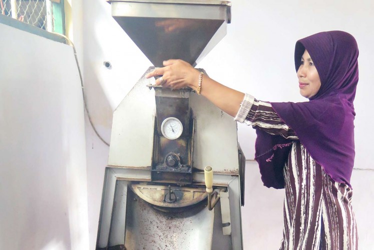 Work in progress: A woman processes Arabica coffee beans at the Selencak Mini Farm in Sumber Wringin, Bondowoso.