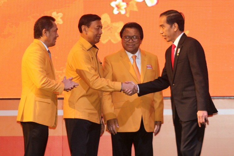 President Joko “Jokowi” Widodo shakes hands with Hanura Party patron Wiranto, who is accompanied by party chairman Oesman Sapta Odang (second right) and secretary general Sarifuddin Sudding (left).