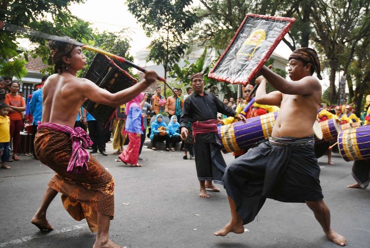 Sword and shield: Men from the West Nusa Tenggaran capital demonstrate the presean warrior dance of Mataram during the 12th Cultural Parade from Jl. Semeru to Gajayana Stadium in Malang, East Java.