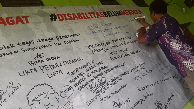 Independent voice: A man expresses his opposition to the government’s plan to issue only one government regulation to implement Law No. 8/2016 on People with Disabilities on a large banner at an Aug.10 advocacy event in Yogyakarta. 