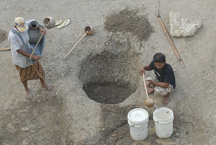 Musuk residents in Boyolali, Central Java, take water from an excavated well in a dried-up river recently.