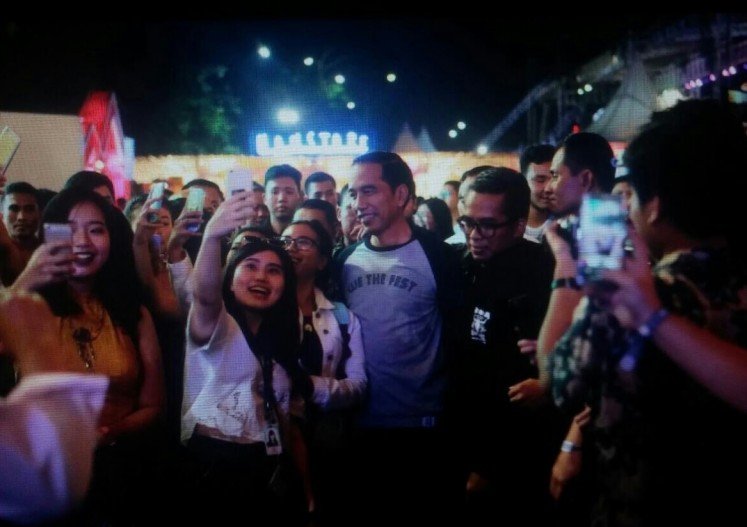 Excited festival-goers take selfies with the President.