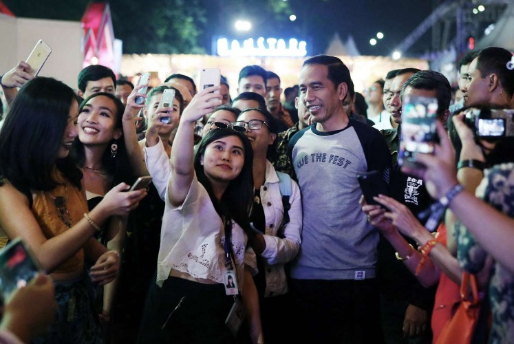 Rare opportunity: We The Fest attendees seize a rare opportunity for selfies with President Joko “Jokowi” Widodo, who attended the event in casual attire.