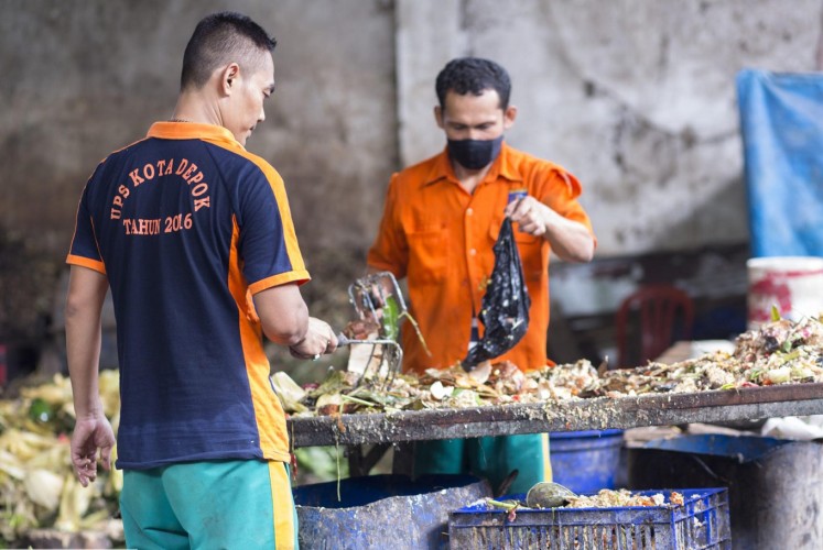 Staff in a huge waste bank (UPS) in Depok, West Java, sort organic waste before it is transformed into compost.