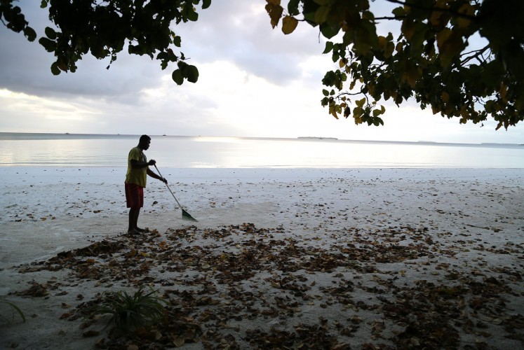 Ngurbloat beach: A resident sweeps up leaves at Ngurbloat beach, the name of which means 