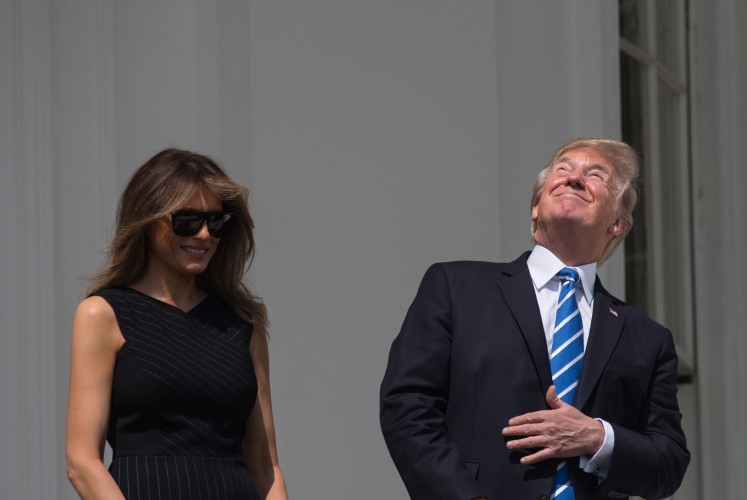 US President Donald Trump and First Lady Melania Trump look up at the partial solar eclipse from the balcony of the White House in Washington, DC, on August 21, 2017. The Great American Eclipse completed its journey across the United States Monday, with the path of totality stretching coast-to-coast for the first time in nearly a century.
Totality began over Oregon at about 1716 GMT and ended at 1848 GMT over Charleston, South Carolina where sky-gazers whooped and cheered as the Moon moved directly in front of the Sun.