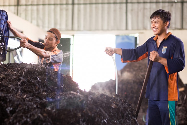 Staff transforming organic waste into compost.