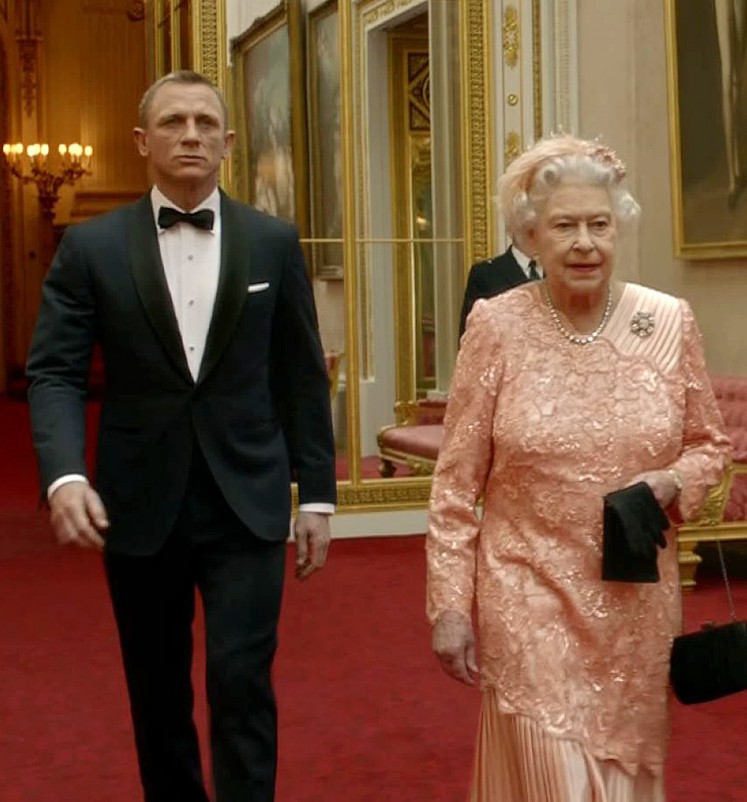 A television screen grab image taken on July 29, 2012, shows footage featured during the Opening Ceremony of the London 2012 Olympic Games starring British actor Daniel Craig (L) playing James Bond escorting Britain's Queen Elizabeth II through the corridors of Buckingham Palace. 