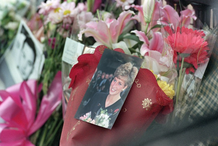 This file photo taken on August 31, 1997 shows tributes placed by the gates of Buckingham Palace in London 31 August 1997 after it was announced that Diana, Princess of Wales, and her companion, the Egyptian millionai film-producer Dodi al-Fayed, died in Paris after a midnight car crash. Public anger at the monarchy following the death of Princess Diana marked a turning point for the royal family, forcing a revolution in its communications machine that helped revive the brand. As mourners left thousands of bouquets of flowers at the gates of Buckingham Palace and nearby Kensington Palace, after Diana's death on August 31, 1997, the royal family were nowhere to be seen.