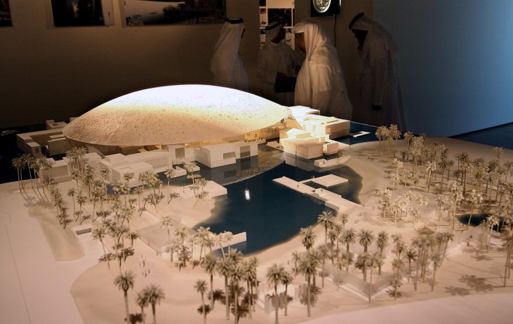 This file photo taken on March 6, 2007 shows Emirati men standing behind a scale model of the new Louvre Abu Dhabi museum. 