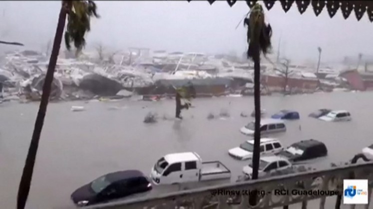 A handout grab image made from a video released on September 6, 2017 by RCI.fm shows flooded streets and damage on the French overseas island of Saint-Martin, filmed from a terrace of the Beach Plaza hotel after high winds from Hurricane Irma hit the island. 