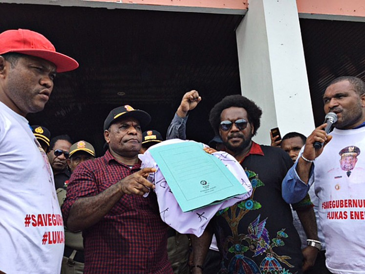 Showing support: Activist Benyamin Gurik (second right) reads out a statement in a rally on Sept. 8 to call for and end to the National Police's investigation into Papua Governor Lukas Enembe. 