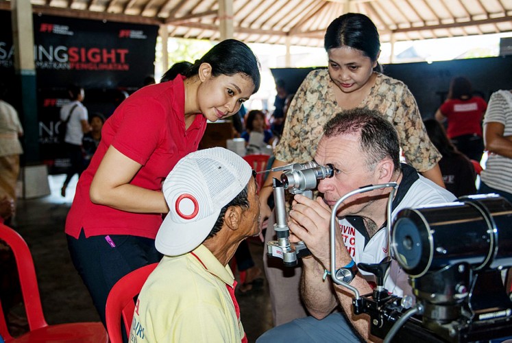 Eye check: UK ophthalmologist Tony Moriarty (right) examines a patient during his time in Bali as a volunteer consultant accompanying the John Fawcett Foundation’s team and local ophthalmologists on village visits. 