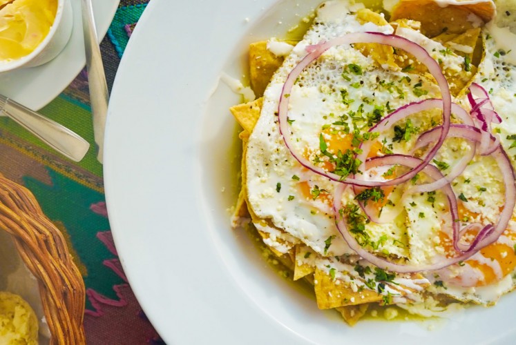 The dish 'chilaquiles' is made from 'totopos' or nachos chips topped with cheese, sauce and other toppings.