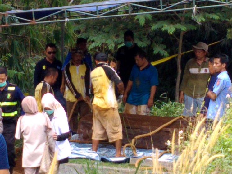 Under investigation: Workers exhume the grave of Hilarius Christian Event Raharjo on Sept. 19 for an autopsy to investigate the cause of his death. 