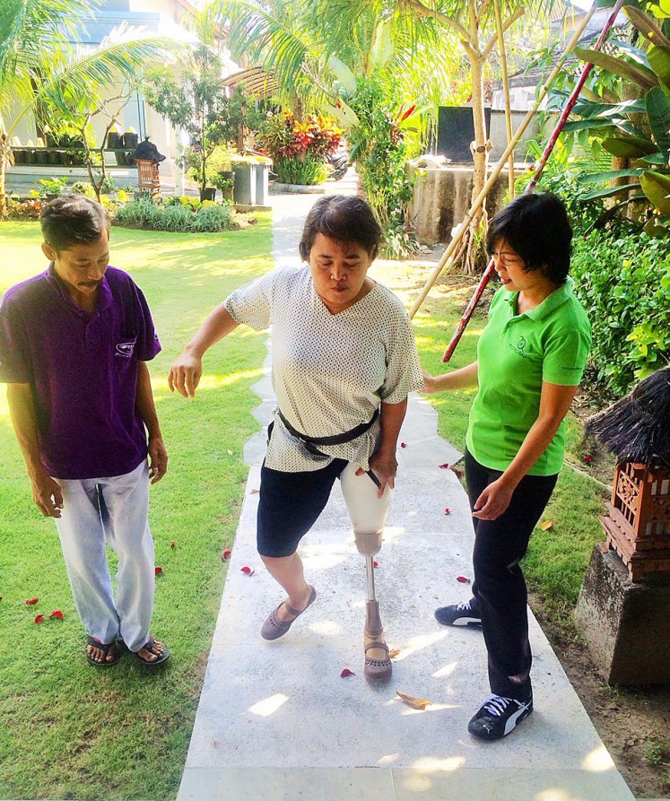 On her feet again: A woman learns to walk using a prosthetic limb in Puspadi, Bali.