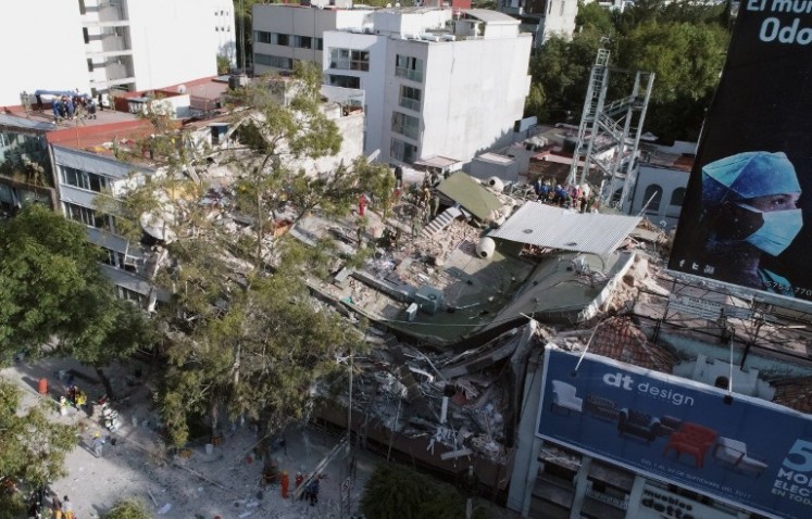 View of buildings flattened by a powerful quake in Mexico City on Sept. 19, 2017. A devastating quake in Mexico on Tuesday killed more than 100 people, according to official tallies, with a preliminary 30 deaths recorded in the capital where rescue efforts were still going on.
