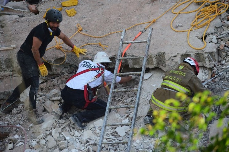 Rescuers search for survivors buried under the rubble and debris of a building flattened by a 7.1-magnitude quake in Mexico City on Sept. 19, 2017. The number of people killed in a devastating earthquake that struck Mexico City and nearby regions on Tuesday has risen to 138, the government said.