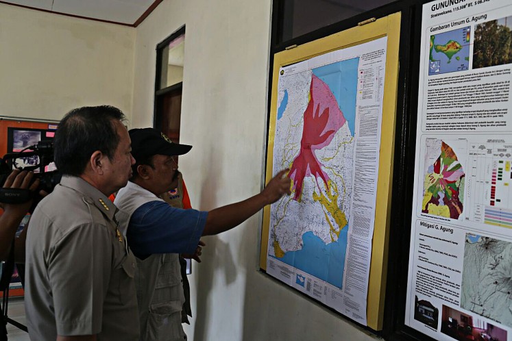 Get ready: An official at the observation post of Mount Agung, Bali, points out the risk zone of the volcano during the visit of National Disaster Mitigation Agency (BNPB) head Willem Rampangilei (left) on Sept. 20
