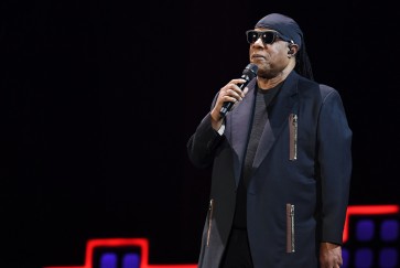 Stevie Wonder kneels as he leads anti-poverty concert