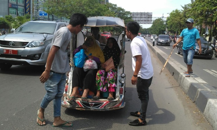 Come on down: People urge pedicab passengers  to take part in a rally against a ban on app-based transportation services in Makassar, South Sulawesi, on Sept.28. 