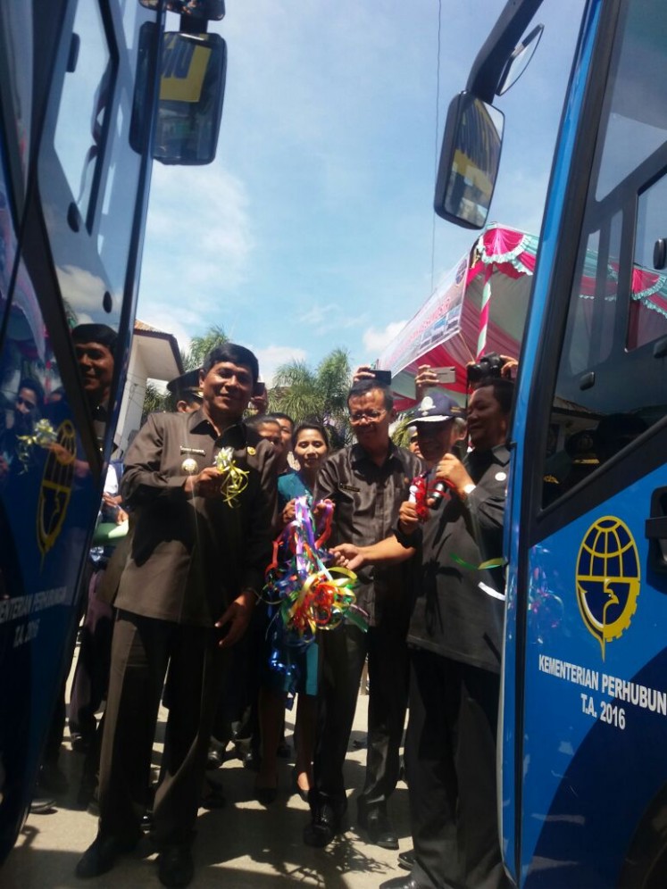 Samosir Regent Rapidin Simbolon (left) inaugurates the operation of two airport buses at the Onan Baru Pangururan bus terminal in Samosir on Sunday. The regency will provide free shuttle service for Samosir air travelers departing from and arriving at Silangit Airport in North Tapanuli regency for three months, after which the bus passengers will be required to pay for the service. 