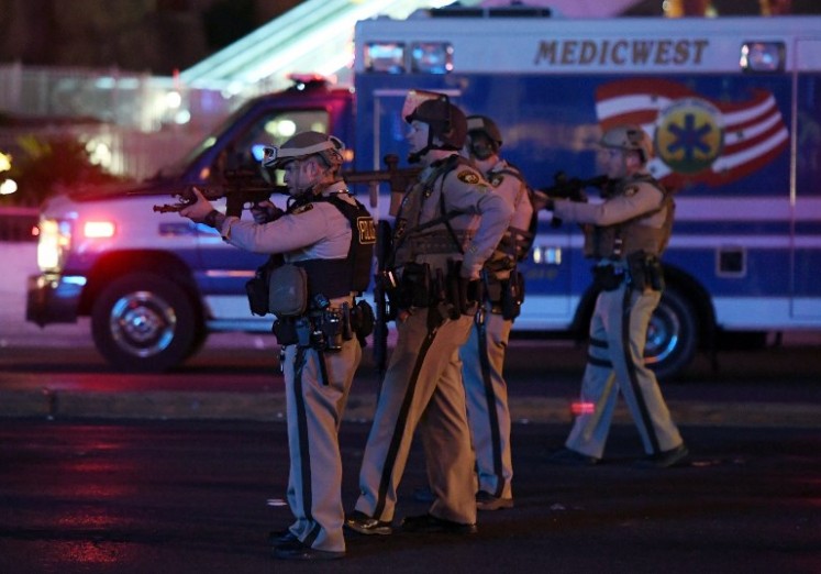 Police officers point their weapons at a car driving down closed Tropicana Ave. near Las Vegas Boulevard after a reported mass shooting at a country music festival nearby on Oct. 2, 2017 in Las Vegas, Nevada. A gunman has opened fire on a music festival in Las Vegas, leaving at least 2 people dead. Police have confirmed that one suspect has been shot. The investigation is ongoing. 